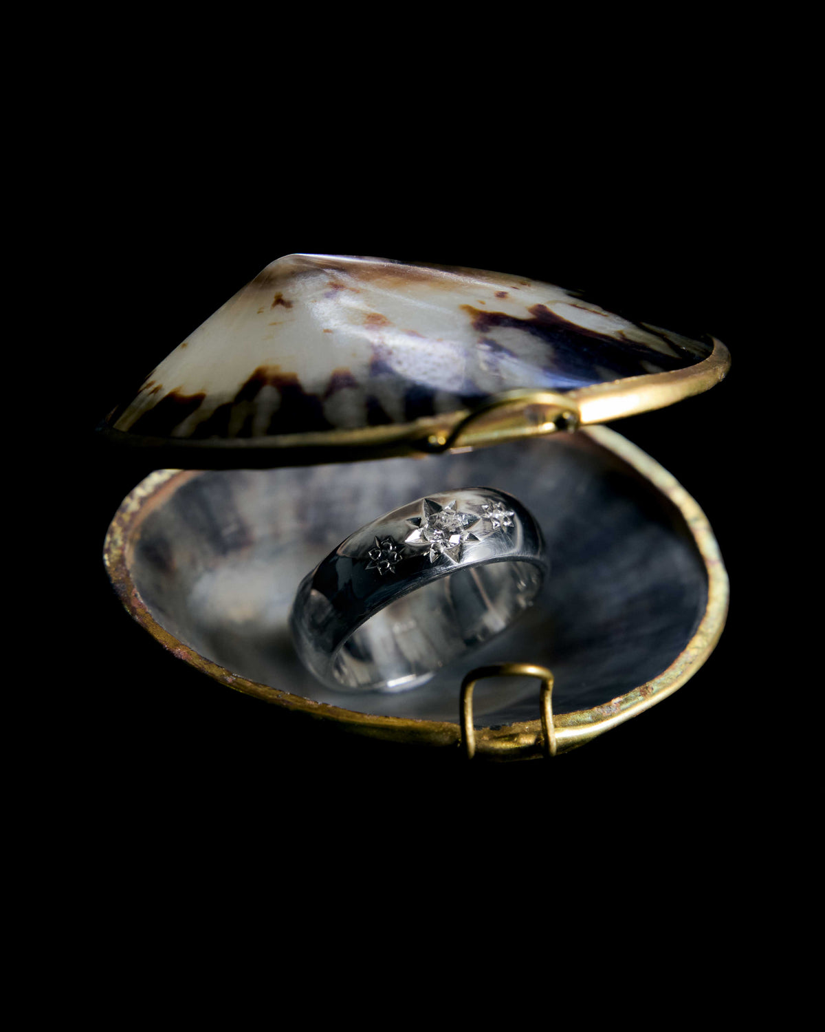 A rectangular cluster ring pave-set with natural diamonds in gold, on a black background