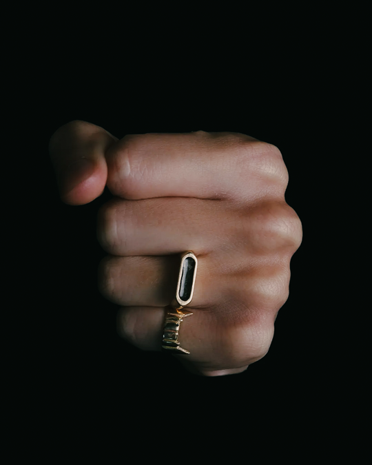 A sterling silver heart ring with ashes sealed over purple enamel, on a white background