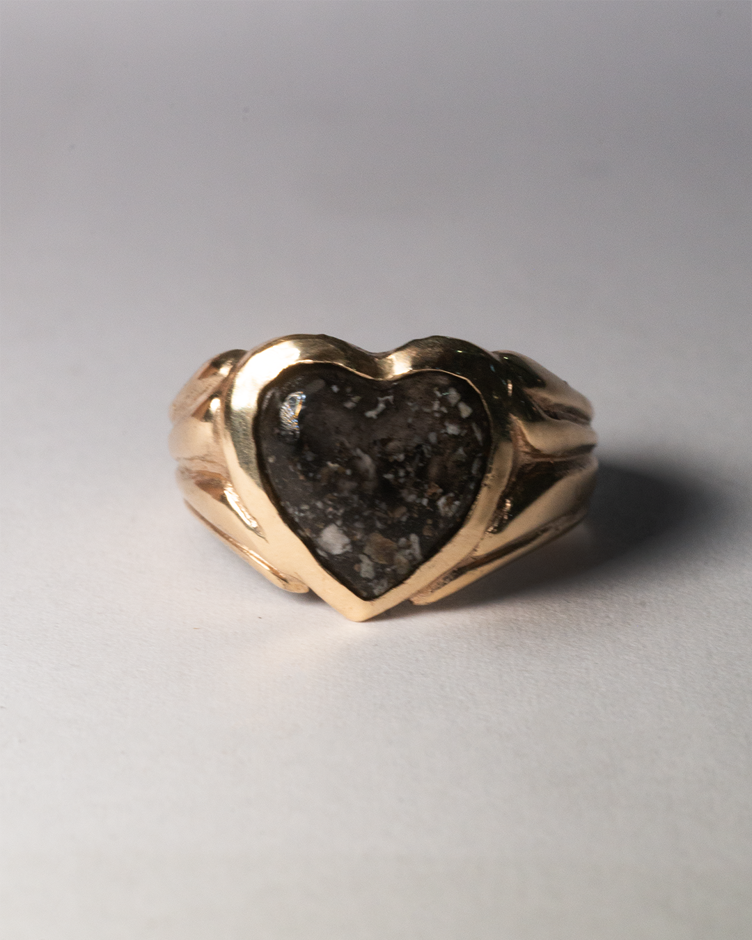 A sterling silver signet ring with cremation ashes sealed under a clear square setting